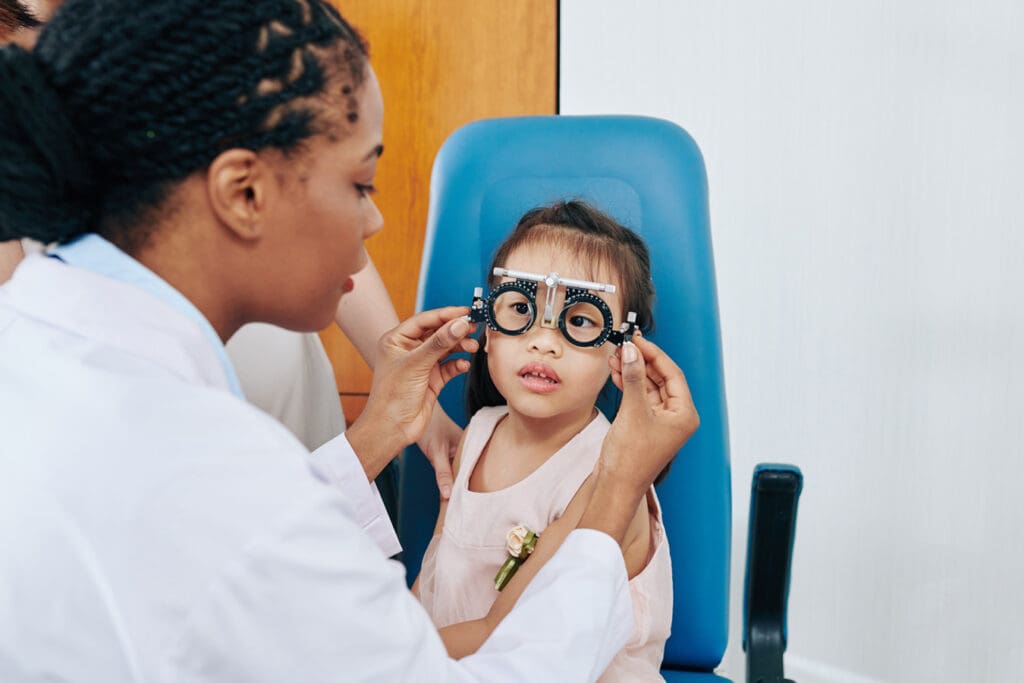 Optomitrist performs an eye exam on girl with amblyopia to determine treatment