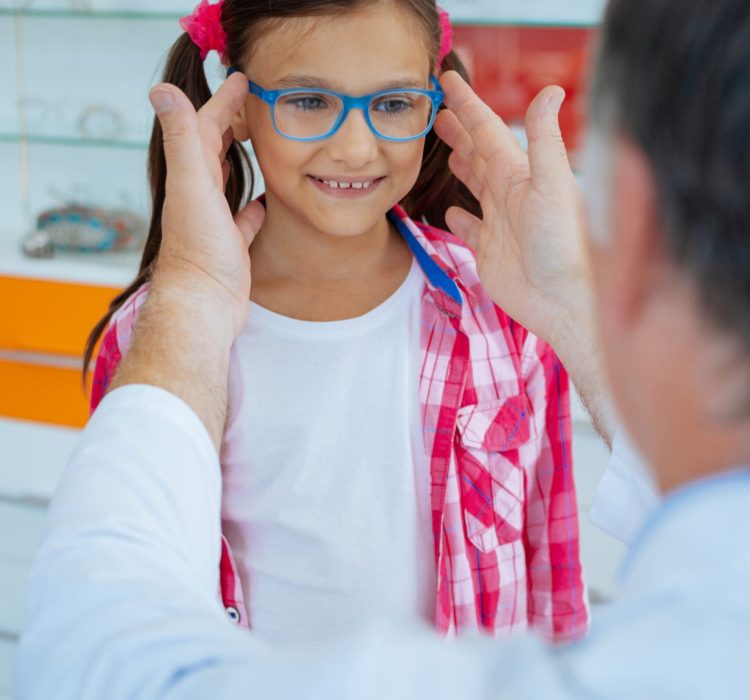 Cheerful positive girl smiling while wearing stylish glasses in a blue frame